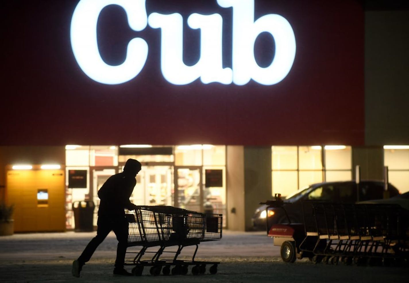 An employee pushed together shopping carts Wednesday night at the Cub location next to the Northtown Mall in Blaine.