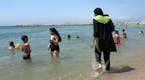 FILE - In this Aug.4 2016 file photo made from video, Nissrine Samali, 20, gets into the sea wearing traditional Islamic dress, in Marseille, southern