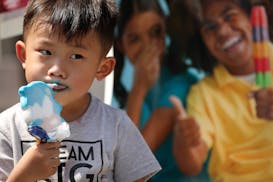 Vincen Vang, 3, of St. Paul sat as he ate an ice cream bar at the Watt Munisotaram Saturday.