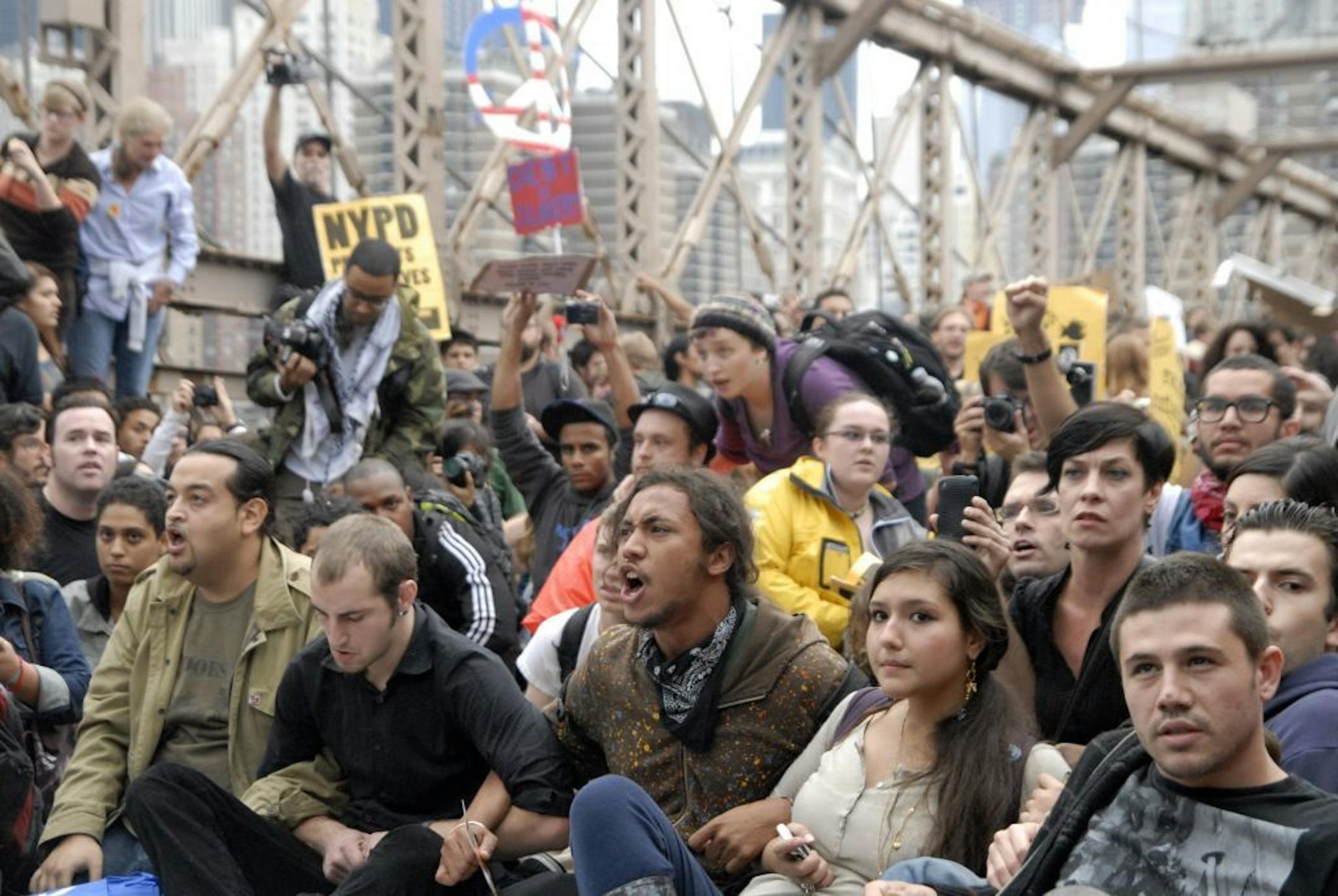 In this Oct. 1, 2011 photo, protesters sit with arms linked on New York's Brooklyn Bridge before police began making arrests during Saturday's march by Occupy Wall Street. Protesters speaking out against corporate greed and other grievances attempted to walk over the bridge from Manhattan, resulting in the arrest of more than 700 during a tense confrontation with police. The majority of those arrested were given citations for disorderly conduct and were released, police said.