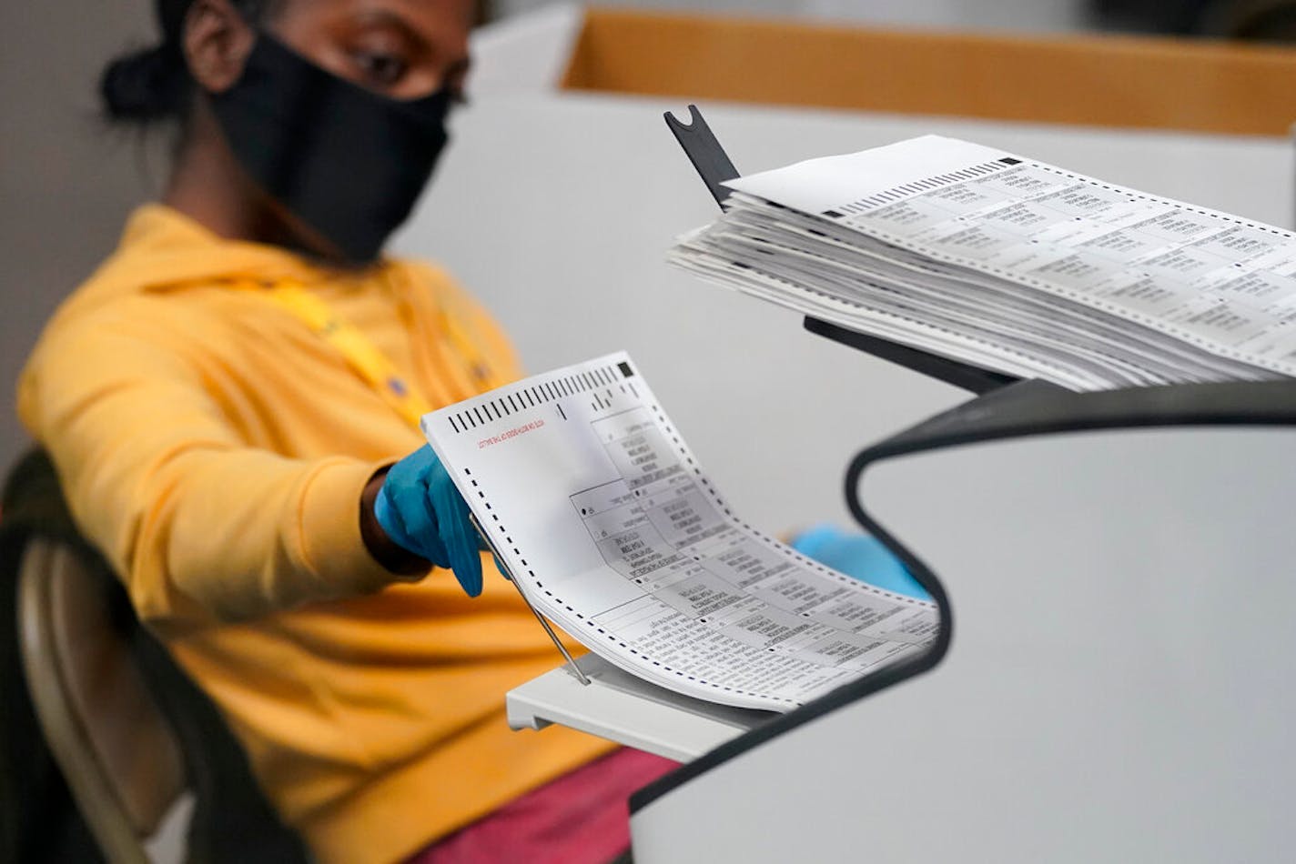 A county election worker scans mail-in ballots at a tabulating area at the Clark County Election Department, Thursday, Nov. 5, 2020, in Las Vegas. (AP Photo/John Locher)