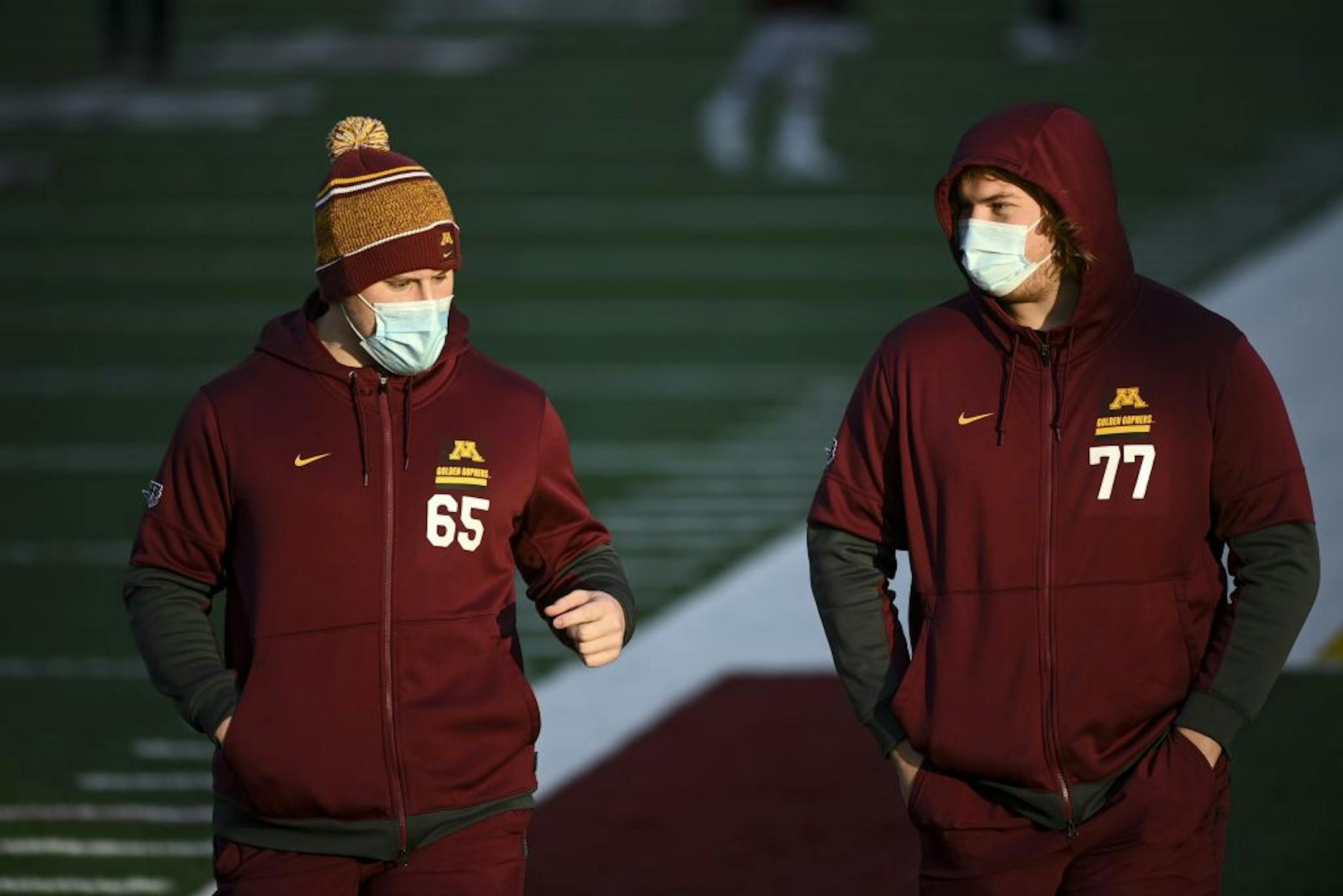 Minnesota Gophers offensive lineman Axel Ruschmeyer (65) and offensive lineman Blaise Andries (77) walked the field before Friday night's game against the Iowa Hawkeyes,