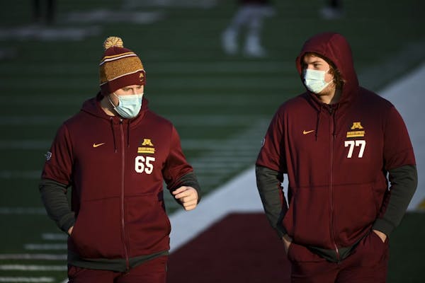 Minnesota Gophers offensive lineman Axel Ruschmeyer (65) and offensive lineman Blaise Andries (77) walked the field before Friday night's game against