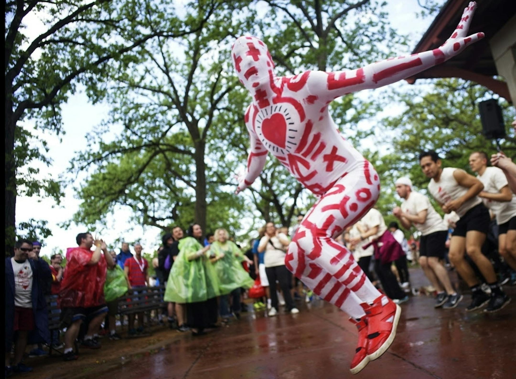 At the start of the MN AIDS Walk 2015 held at Minnehaha Park, Doug Melroe helped get walkers warmed up for the 10K event. "I have lost many friends. They are my heroes and angels," said the Firm instructor who wore a Keith Haring inspired suit made by his partner.