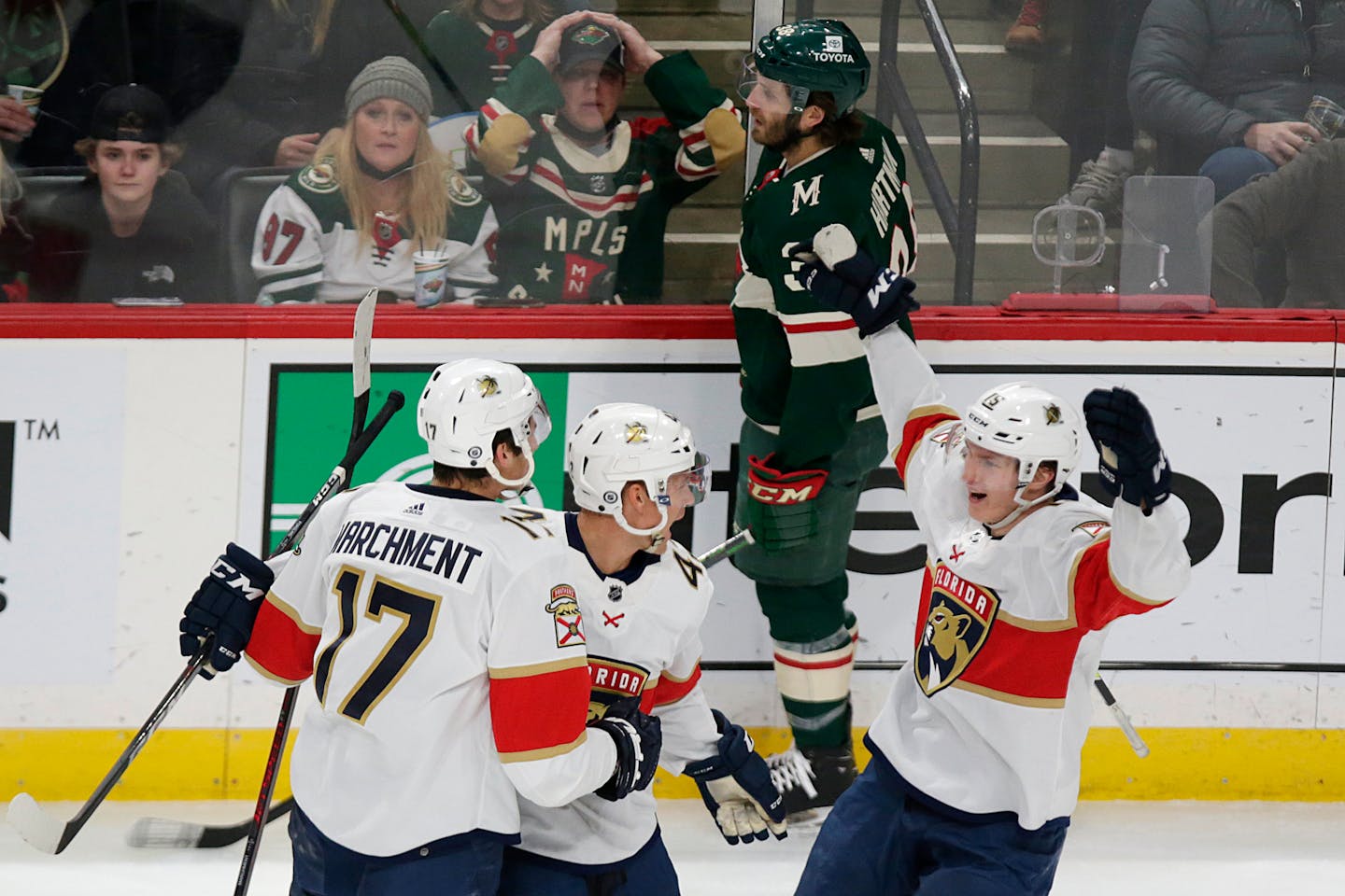 Panthers left wing Mason Marchment celebrates his goal with teammates Gustav Forsling (42) and Anton Lundell (15) as Wild right wing Ryan Hartman skates by.