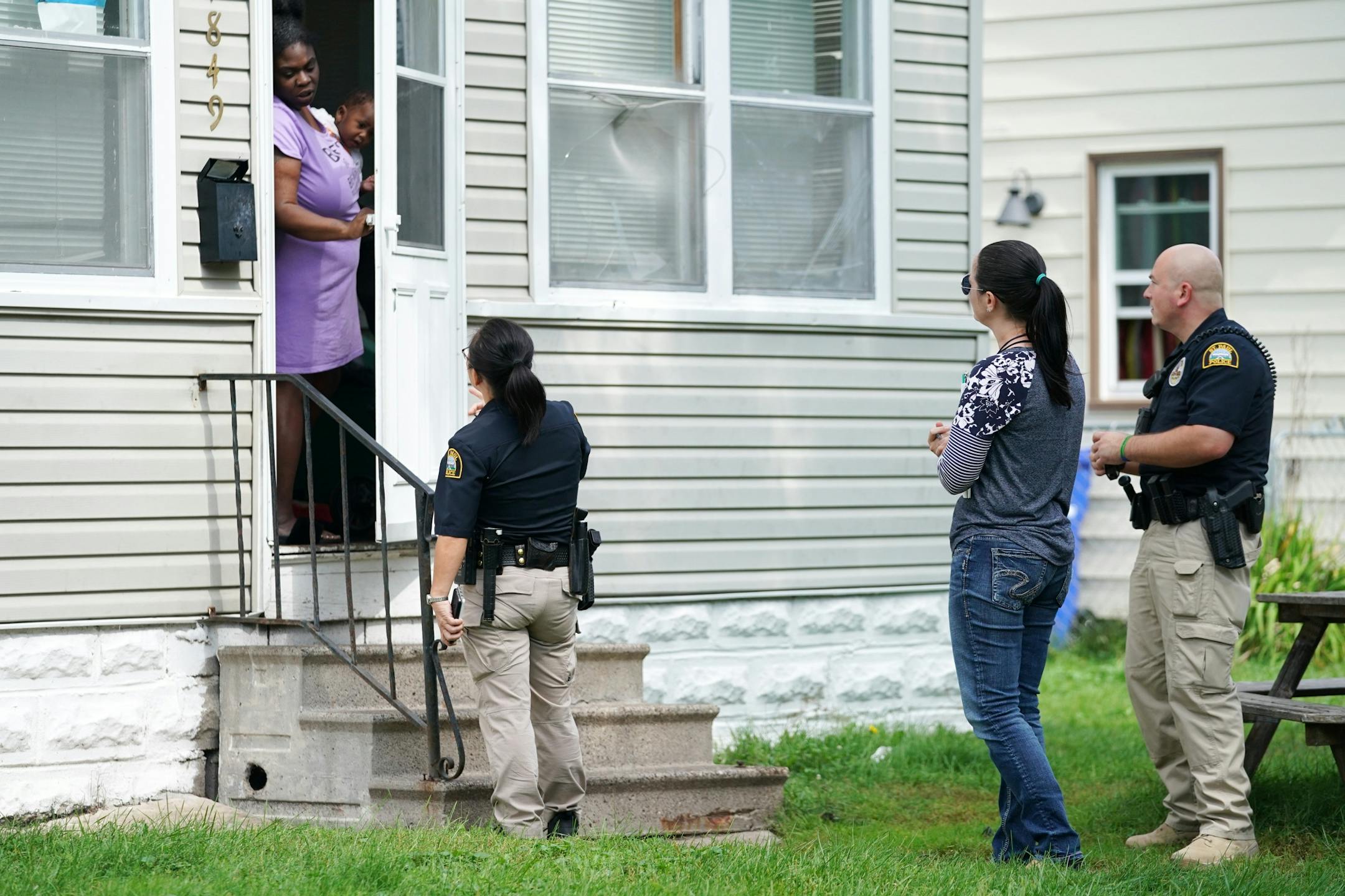 Licensed clinical social worker Kara Haroldson, center, stood with officers Lori Goulet and Justin Tiffany as they checked with a woman they had previous contact with.