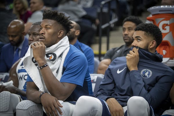 Timberwolves guard Jimmy Butler, left, and Timberwolves center Karl-Anthony Towns watched the game from the bench during the fourth quarter as the Min