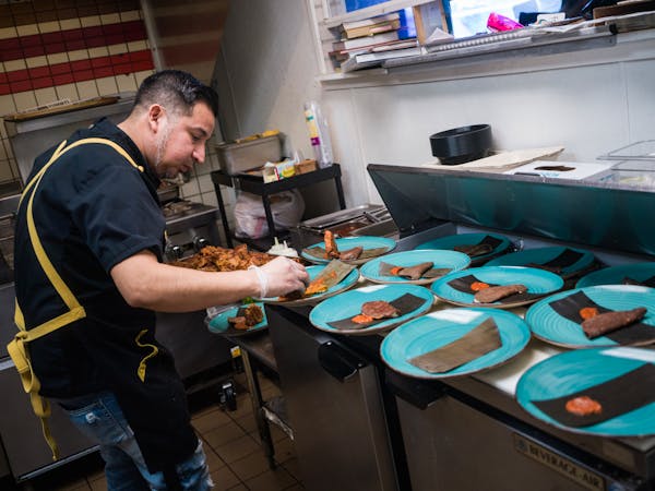 Chef Christian de Leon plates up lamb birria in the crowded kitchen in Eagan, Minn., on Sunday, March 26, 2023.