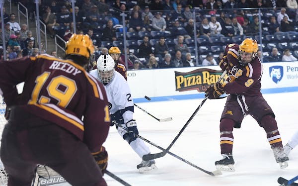 Minnesota center Mike Szmatula (9) shoots on goal as Penn State's Cole Hults defends during Friday's Big Ten Quarterfinals Game 1 at Univesity Park, P