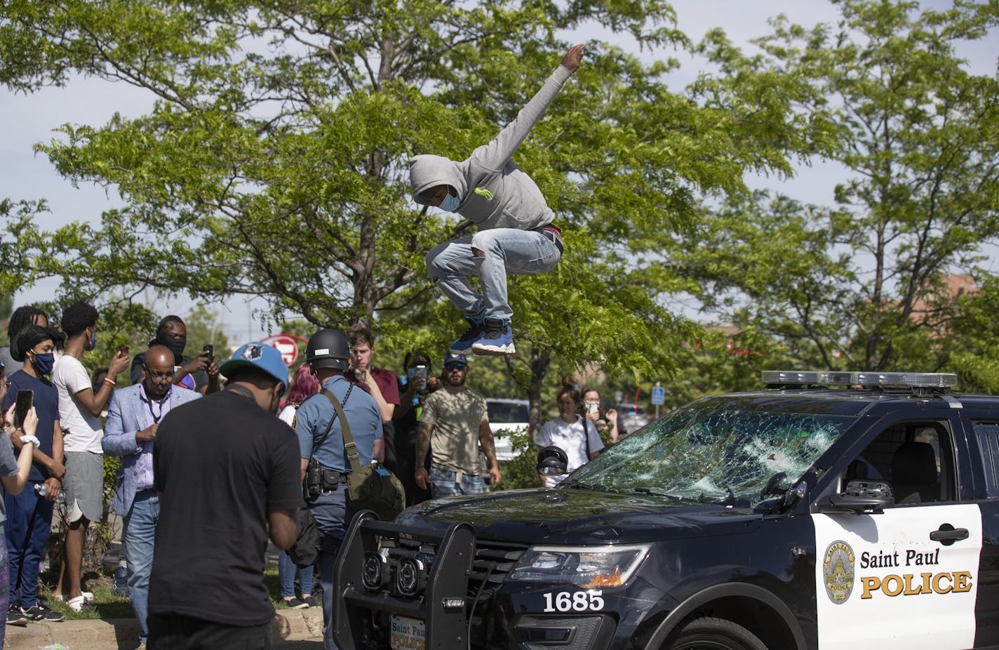 A protestors jump off an heavily damaged St. Paul squad car at the Super Target .