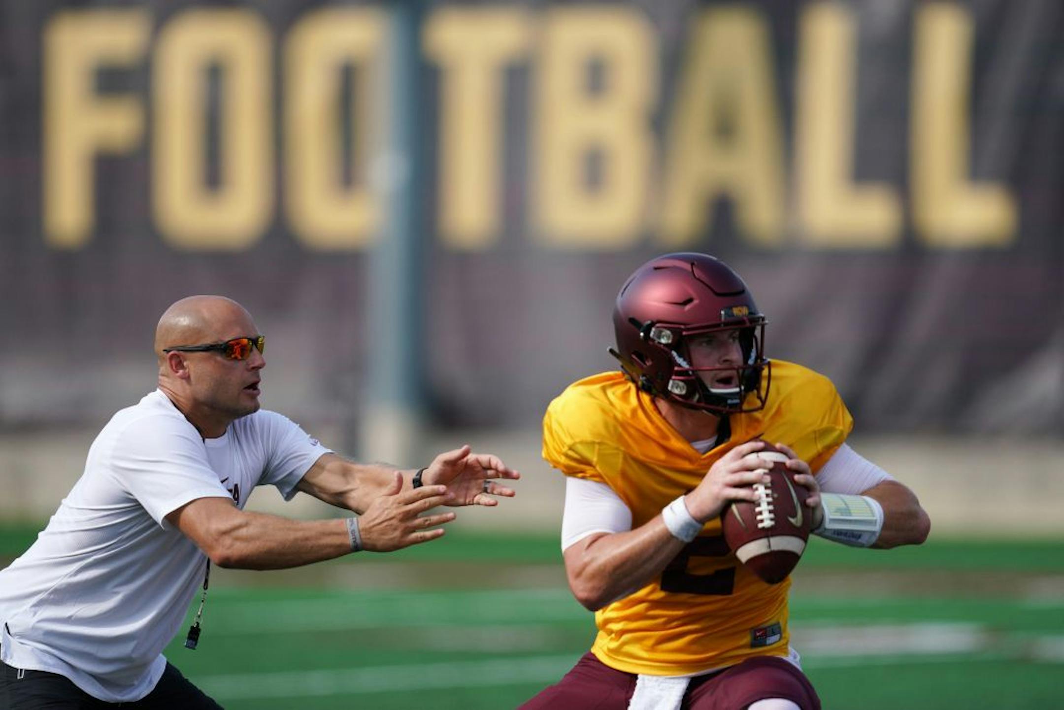Minnesota Golden Gophers head football coach P. J. Fleck rushed quarterback Tanner Morgan (2) during practice Friday.