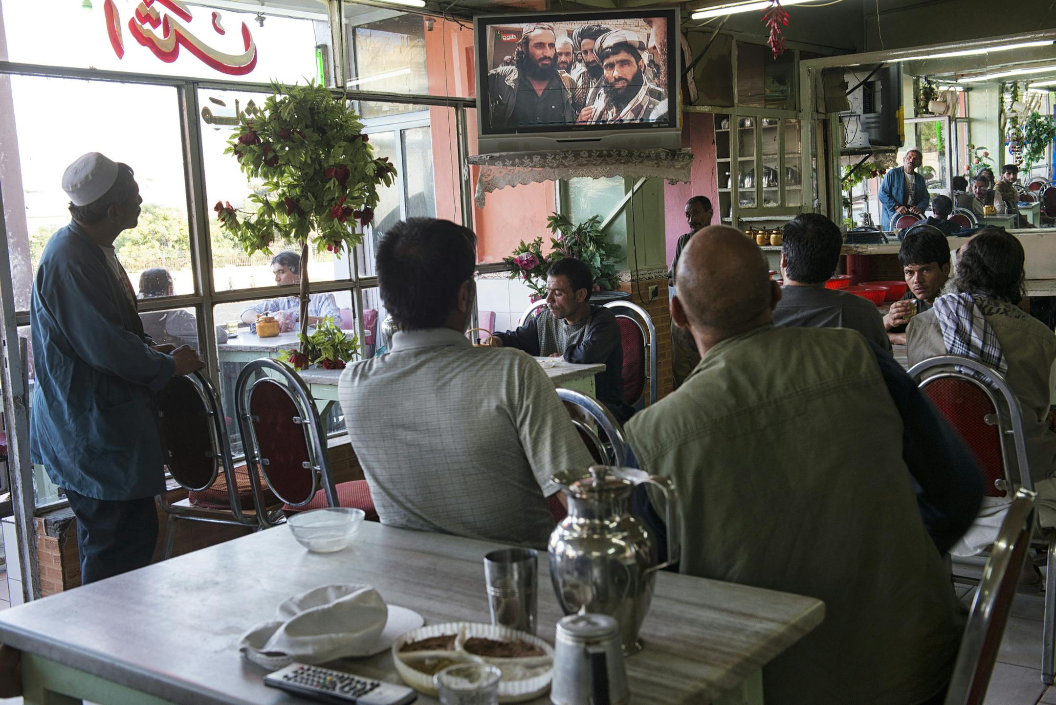 FILE -- Afghans, watching news coverage about peace talks between the Taliban and the Afghan government, at a cafe in Kabul, Afghanistan, in June 19, 2013. The Taliban confirmed Thursday that their supreme leader, Mullah Muhammad Omar, had died as the struggle to replace him was underway. (Lynsey Addario/The New York Times) -- NO SALES --