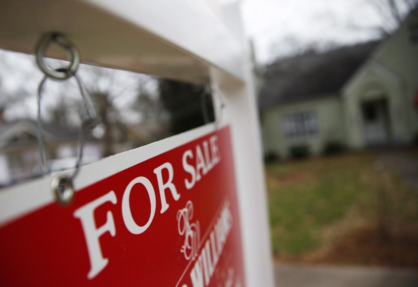 FILE - This Jan. 26, 2016 file photo shows a "For Sale" sign hanging in front of an existing home in Atlanta. Short of savings and burdened by debt, America's millennials are struggling to afford their first homes in the face of sharply higher prices in many of the most desirable cities. Surveys show that most Americans under 35 lack adequate savings for down payments. The result is that many will likely be forced to delay home ownership and to absorb significant debt loads if they do eventually