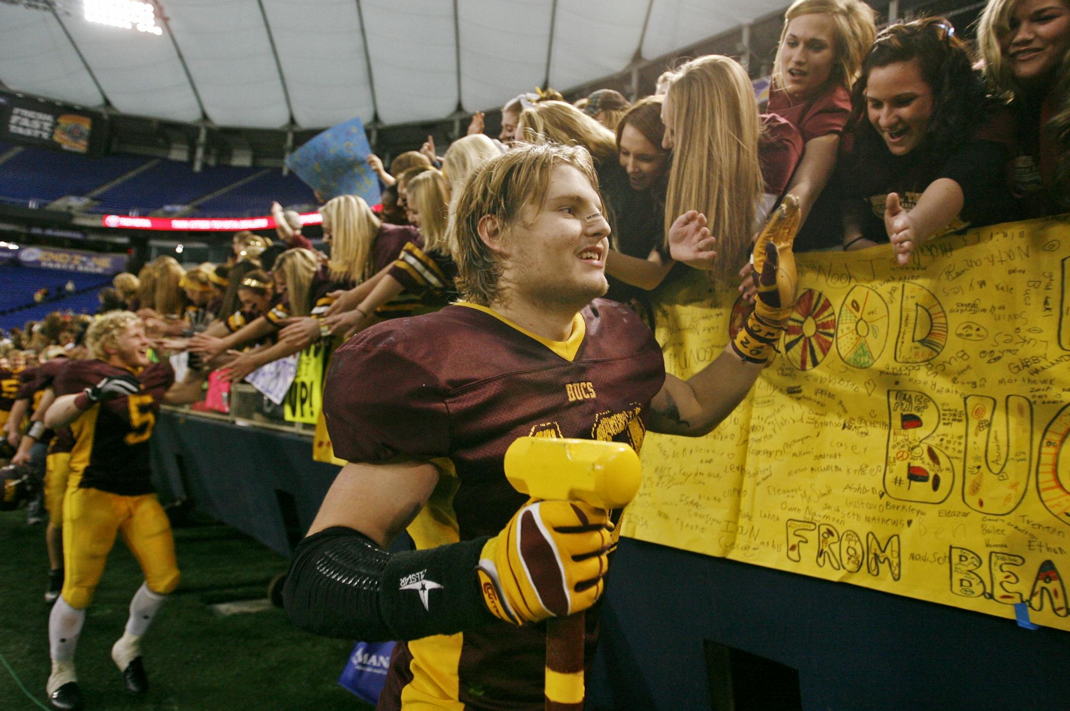 Blue Earth Area's Steven Plocker, front, and teammates received congratulations from grateful fans following Blue Earth's 30-7 win over beat Rochester Lourdes at the 3A Prep Bowl championship at the Metrodome Saturday, Nov. 24, 2012, in Minneapolis, MN.