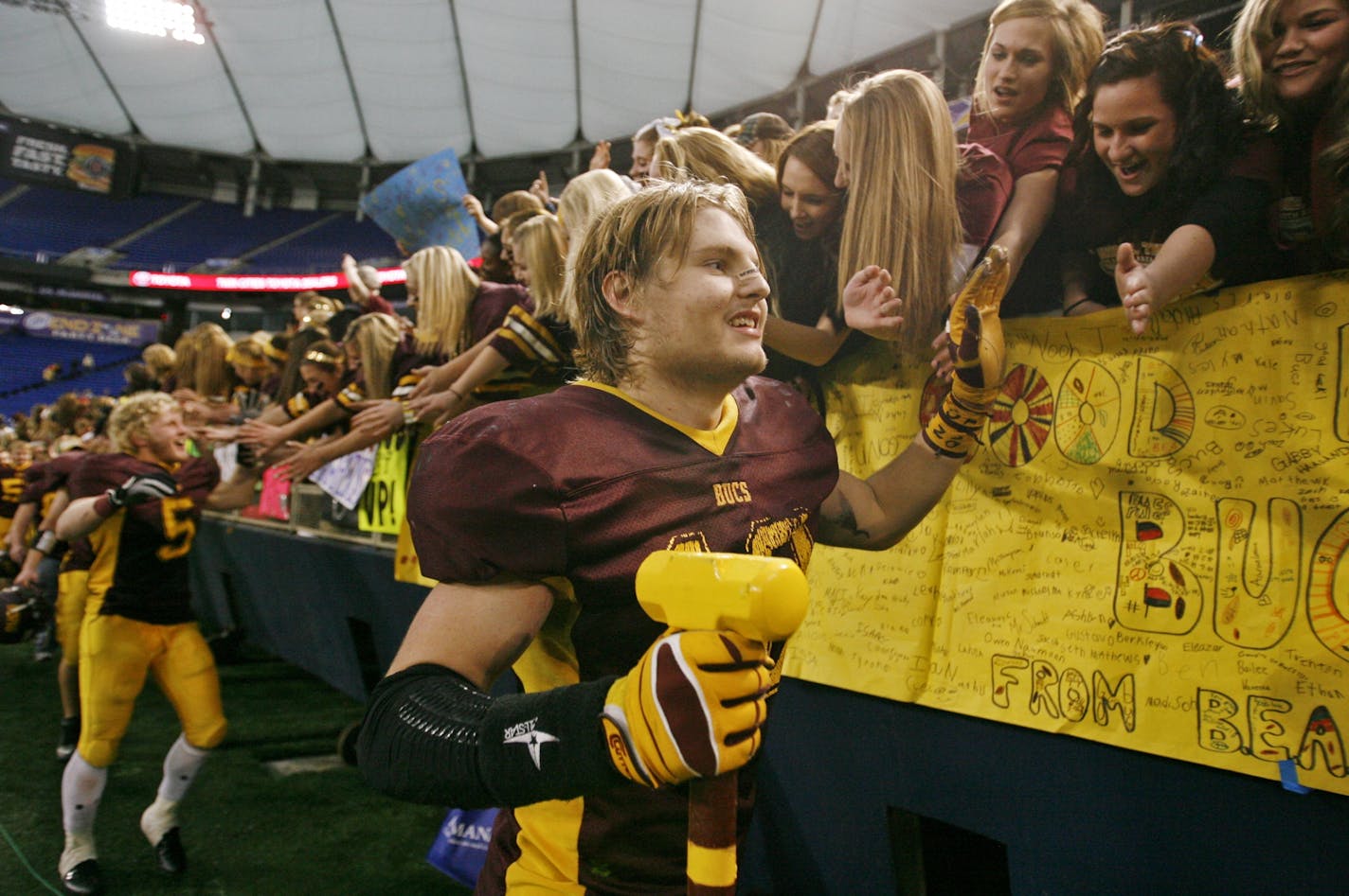 Blue Earth Area's Steven Plocker, front, and teammates received congratulations from grateful fans following Blue Earth's 30-7 win over beat Rochester Lourdes at the 3A Prep Bowl championship at the Metrodome Saturday, Nov. 24, 2012, in Minneapolis, MN.