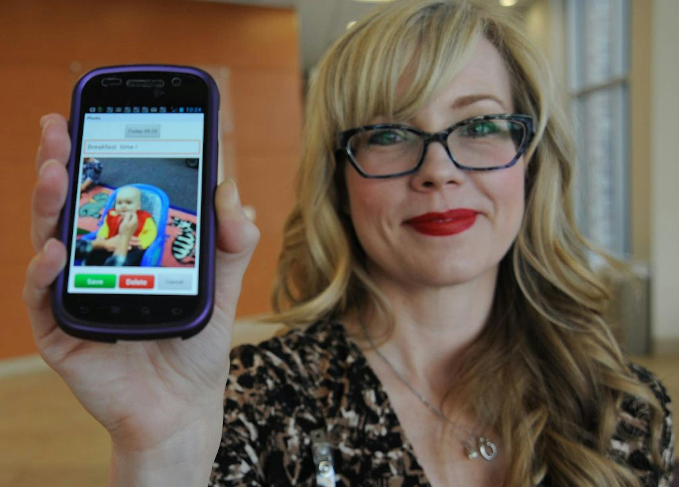 Stephanie Malone has her phone close by to receive updates of her five-month-old son, who attends Kinderberry Hill in Roseville, Minn.