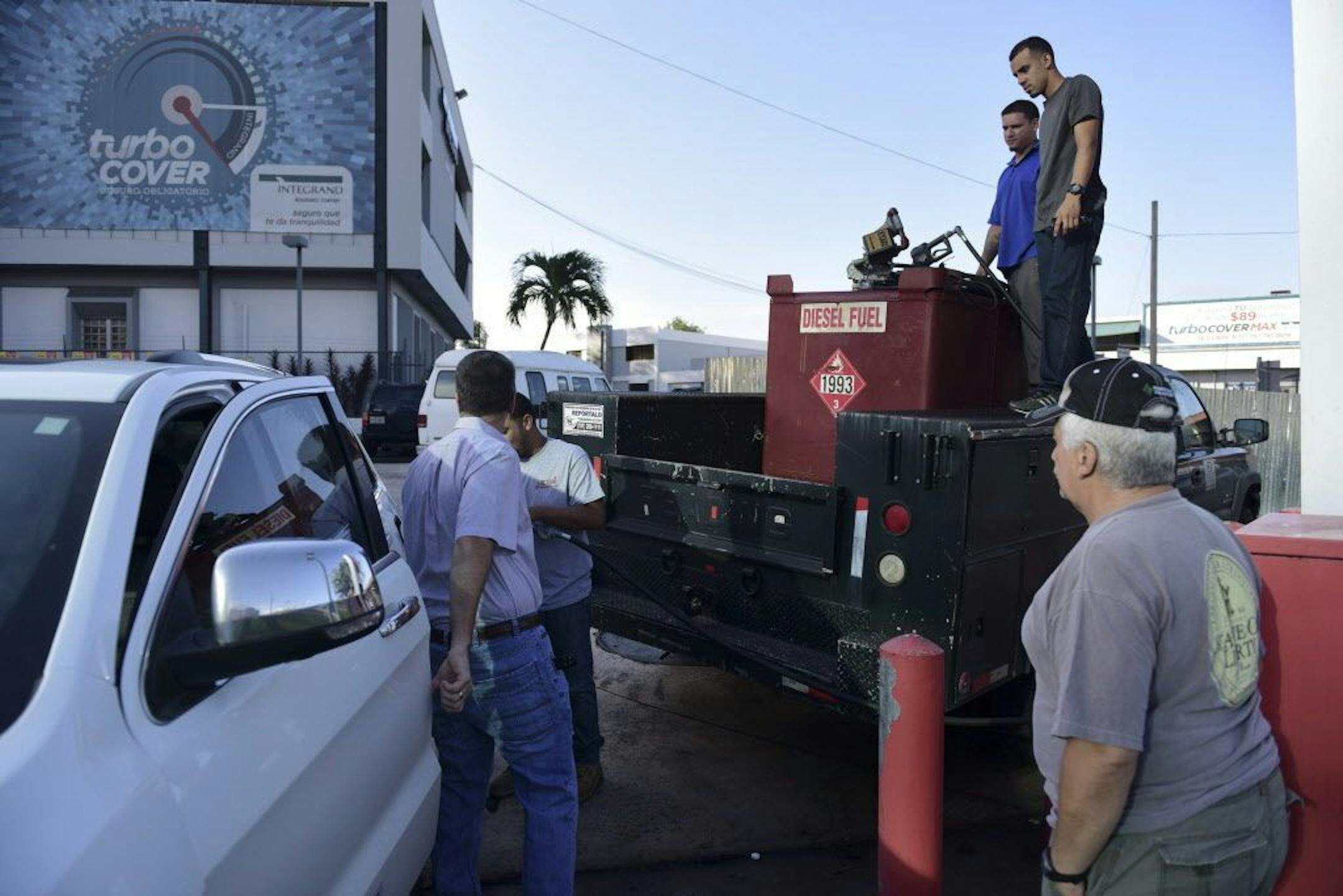 Department of Education employees fill a generator with diesel in San Juan, Puerto Rico, Thursday, Sept. 22, 2016, after a massive blackout hit Puerto Rico Wednesday afternoon, leaving at least 1.5 million people without power overnight and into the following day.