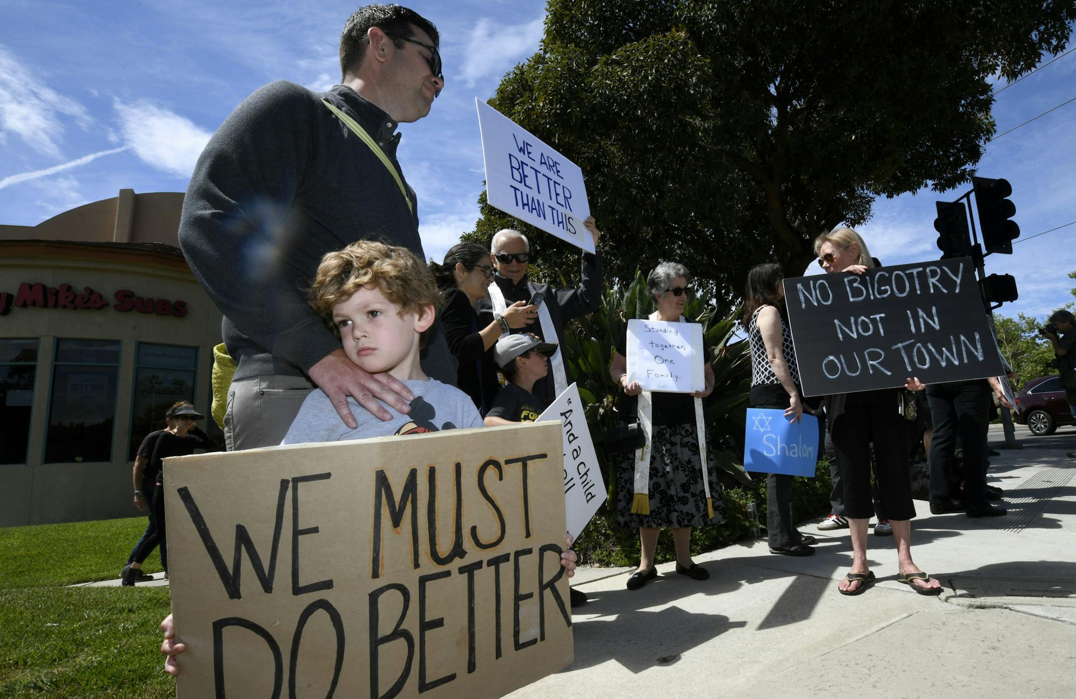 Kyle Fox, 4, and his father Brady Fox hold a sign at a vigil held to support the victims of Chabad of Poway synagogue shooting on the last day of Passover last month in Poway, Calif. A man opened fire Saturday inside the synagogue near San Diego as worshippers celebrated the last day of a major Jewish holiday. FBI officials testified Wednesday that the agency has more than 850 open investigations into domestic terrorism across the country, and the threat continues to grow.