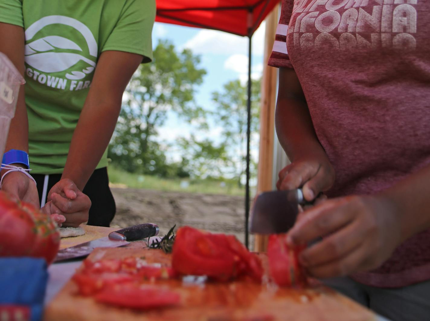 TC Xiong (left) and Alecia Mathews prepare pizzas to be baked and shared with people at Frogtown Farms. ] Shari L. Gross &#xef; shari.gross@startribune.com The Minnesota Superbowl Committee is giving $50,000 to St. Paul's Frogtown Farm to develop an outdoor kitchen and other features. The money is meant to encourage health and wellness in Minnesota and is part of $2 million granted to Minnesota organizations from the Super Bowl folks. Photographed Tuesday, August 22, 2017.