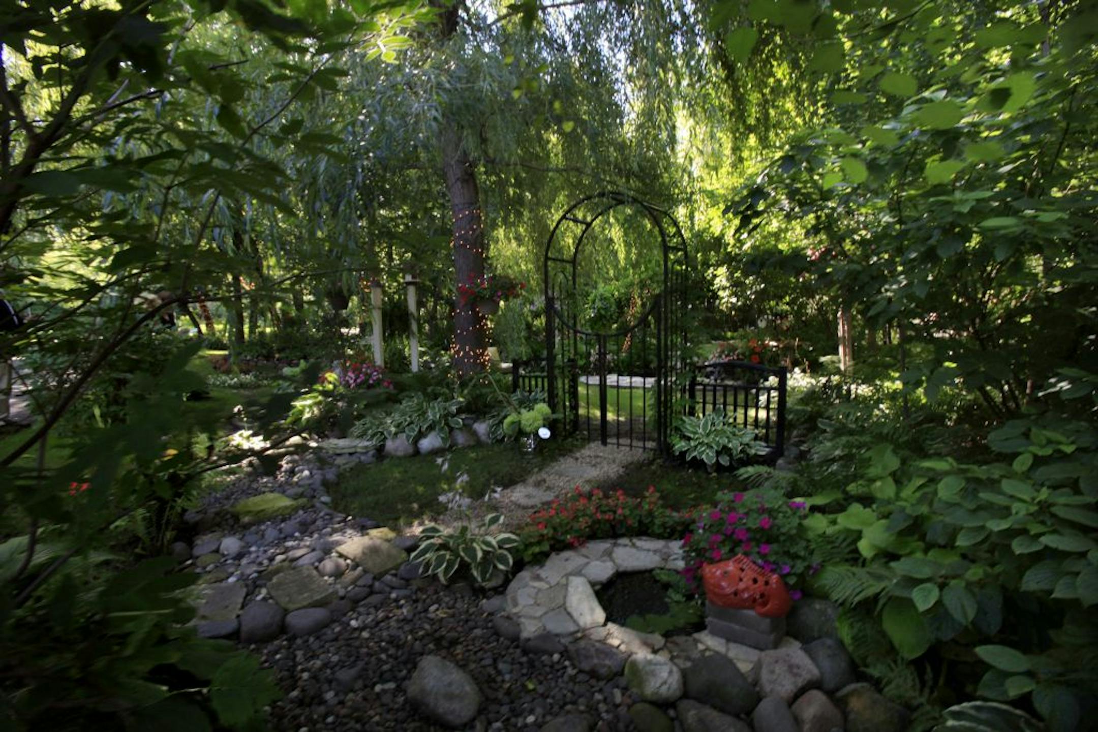 Michelle Chambers Blair and Brian Blair removed a kids' sandbox and slide tower and dug out a pond, which they accented with two waterfalls and "Rebecca at the Well" statue. They added koi and aquatic plants and planted the surrounding shade gardens with ferns and hosta.