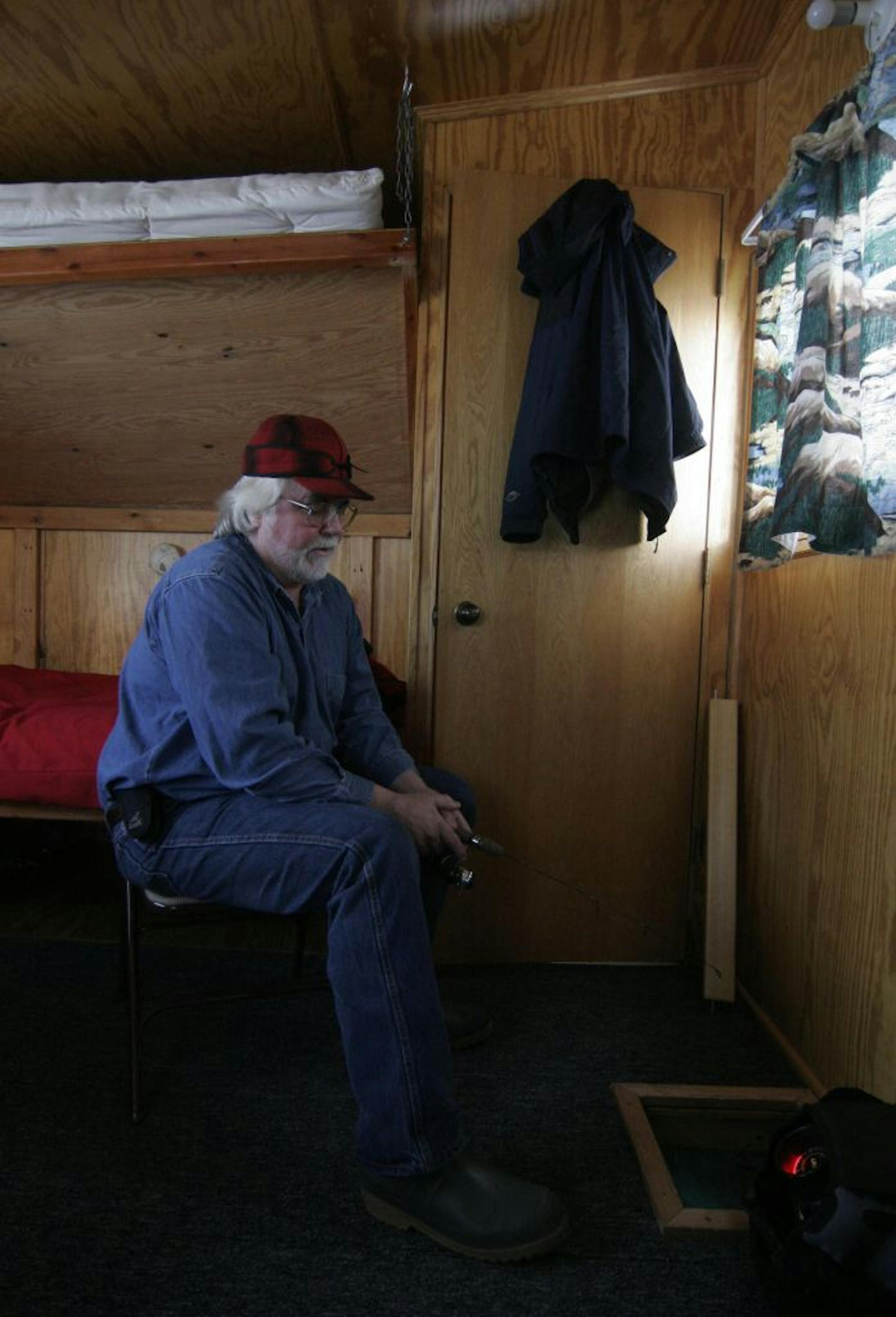 Eddy Lyback took time off from running Lyback's Ice Fishing business to fish in one of his rental ice houses for perch and walleyes Monday. This heated house has bunks, a table and a stove — and six holes to fish from.