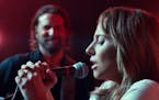 Lady Gaga's character, Ally, takes the mike onstage as Bradley Cooper looks on. (Warner Bros. Pictures) ORG XMIT: 1241642