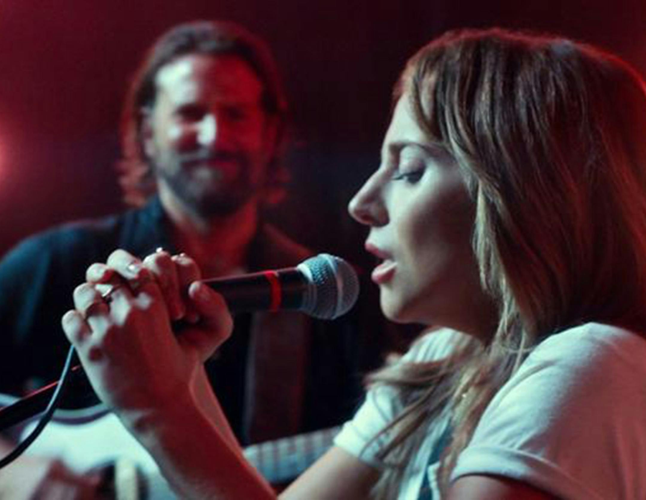 Lady Gaga's character, Ally, takes the mike onstage as Bradley Cooper looks on. (Warner Bros. Pictures) ORG XMIT: 1241642