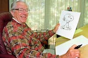 In this Feb. 12, 2000, file photo, cartoonist Charles Schulz displayed a sketch of his beloved character “Snoopy.”