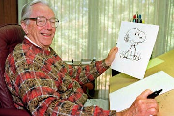 In this Feb. 12, 2000, file photo, cartoonist Charles Schulz displayed a sketch of his beloved character “Snoopy.”