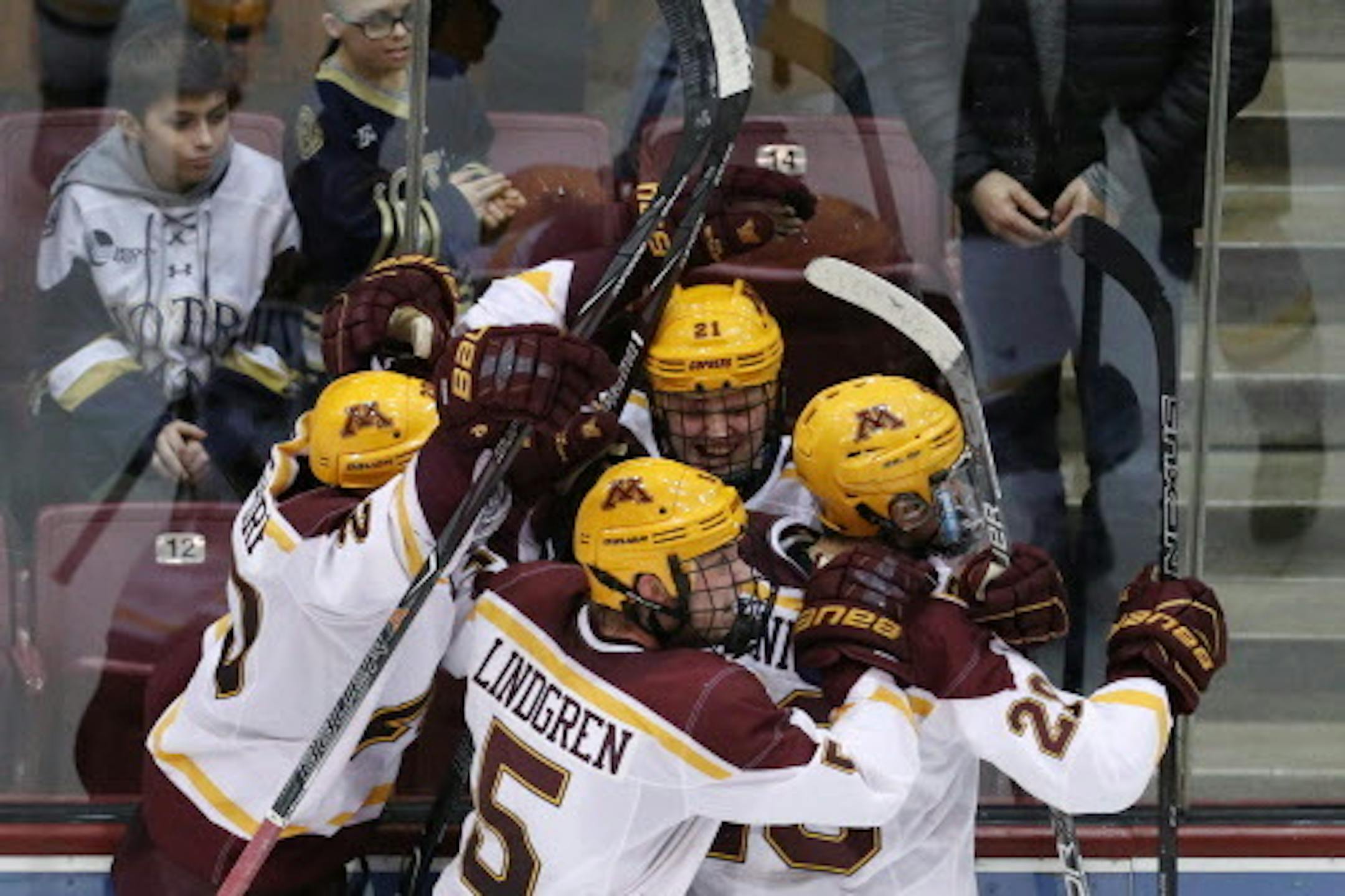 Minnesota Golden Gophers forward Casey Mittelstadt (21) celebrated with his teammates after scoring the game winning goal on Notre Dame Fighting Irish goaltender Cale Morris (32) in overtime. ] ANTHONY SOUFFLE ' anthony.souffle@startribune.com