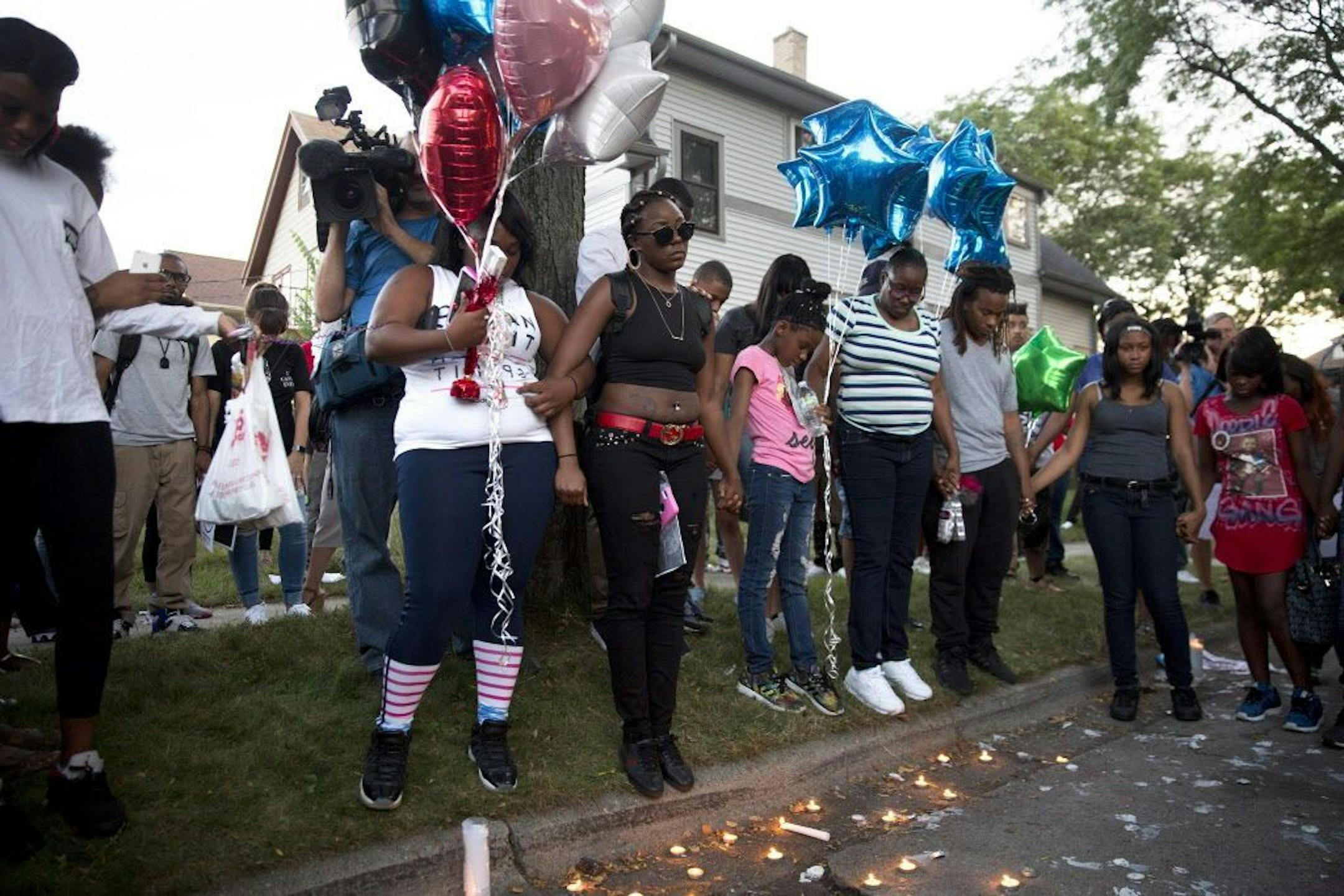From center, Kimberly O'Neal, the sister of Sylville Smith, who was shot by the Milwaukee police the day before, stands with supporters during a vigil for her brother Sunday, Aug. 14, 2016, in Milwaukee, Wis.