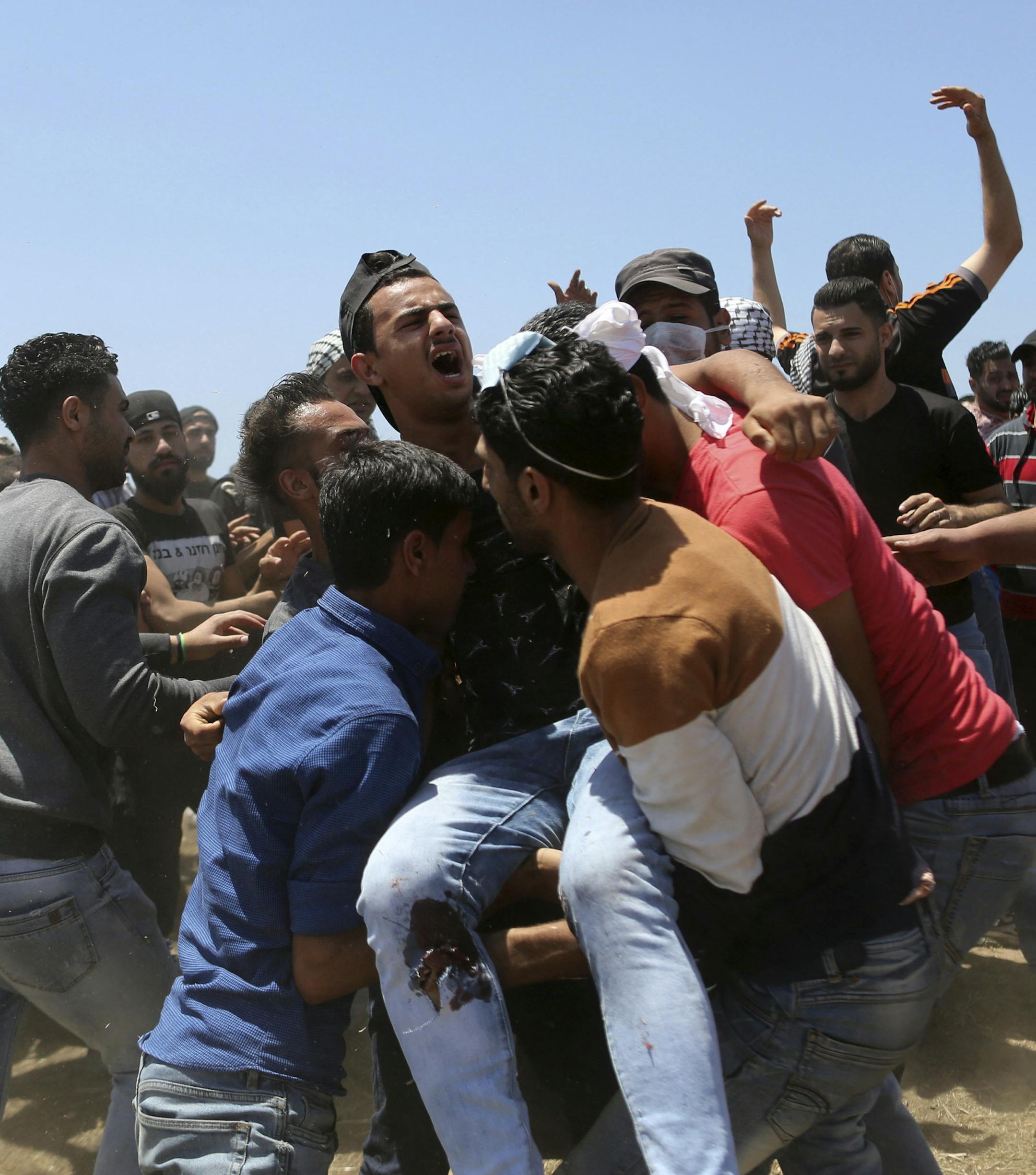 Palestinian protesters carry a wounded protester during clashes after protests near the border with Israel in the east of Gaza Strip, 14 May 2018. More protests are expected in the Palestinian territories on 15 May. At least 58 Palestinian protesters were killed and more than 2,000 others were injured at the Gaza-Israeli border during clashes against the US embassy move to Jerusalem as well as marking the Nakba Day. Palestinians are marking the Nakba Day, or the day of the disaster, when more th