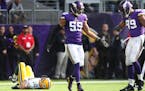 Minnesota Vikings outside linebacker Anthony Barr (55) celebrates with Danielle Hunter as Green Bay Packers quarterback Aaron Rodgers (12) lays on the