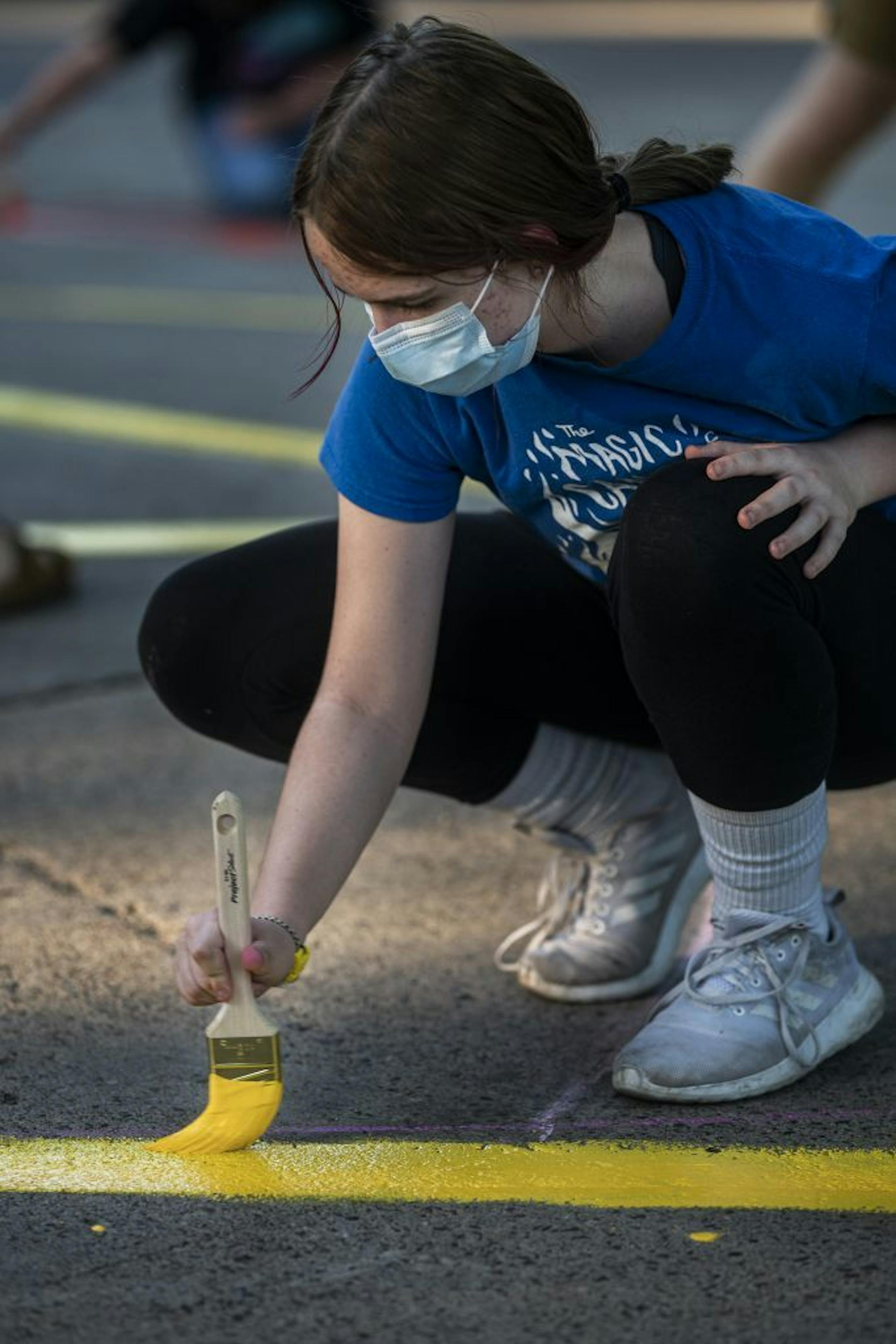 Kylee Blazina,14, helps paint a peace sign.