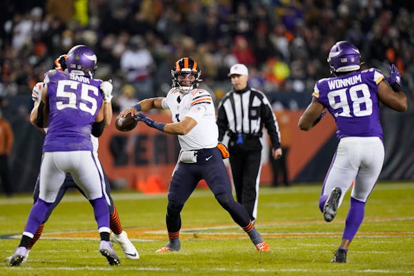 Chicago Bears quarterback Justin Fields (1) passes between Minnesota Vikings outside linebacker Anthony Barr (55) and defensive end D.J. Wonnum during