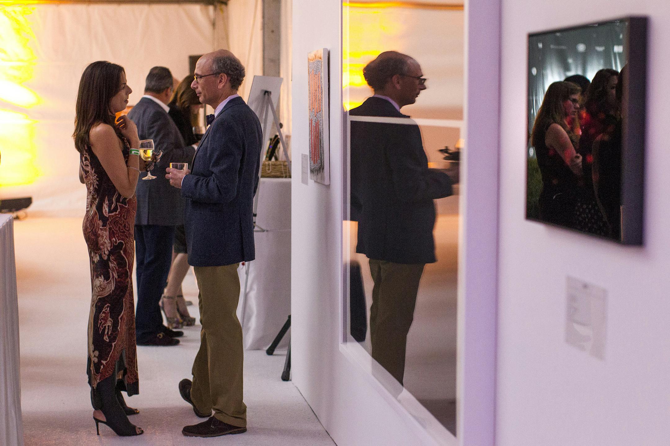 Sally Blanks, left, and Alan Polsky converse near the art auction items at Avant Garden at the Walker Art Center September 21, 2013. (Courtney Perry/Special to the Star Tribune)