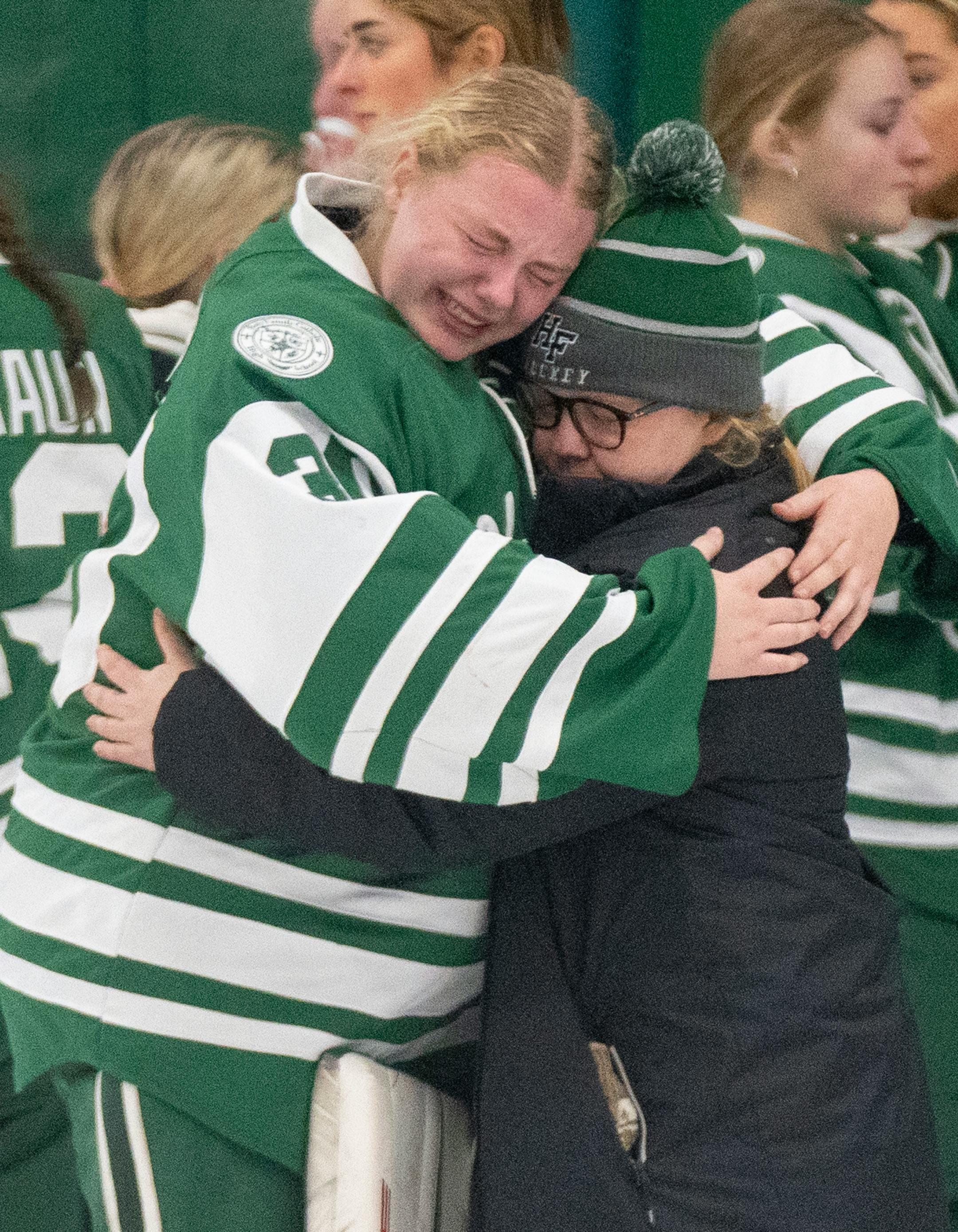 Holy Family goaltender Sedona Blair (30) is embraced after losing 4-0 to Minnetonka.