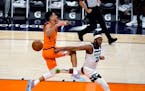 Minnesota Timberwolves forward Josh Okogie (20) knocks the ball away from Phoenix Suns guard Devin Booker during the second half of an NBA basketball 