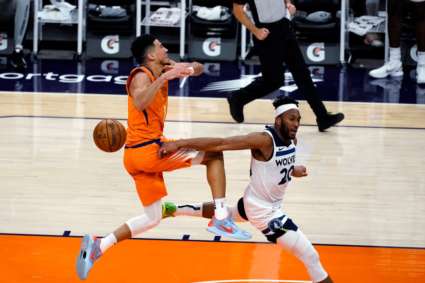 Minnesota Timberwolves forward Josh Okogie (20) knocks the ball away from Phoenix Suns guard Devin Booker during the second half of an NBA basketball game Friday, March 19, 2021, in Phoenix. Phoenix won 113-101. (AP Photo/Rick Scuteri)