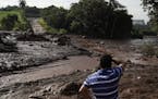 A man stands at a blocked road after a dam collapsed near Brumadinho, Brazil, Saturday, Jan. 26, 2019. The dam that held back mining waste collapsed, 