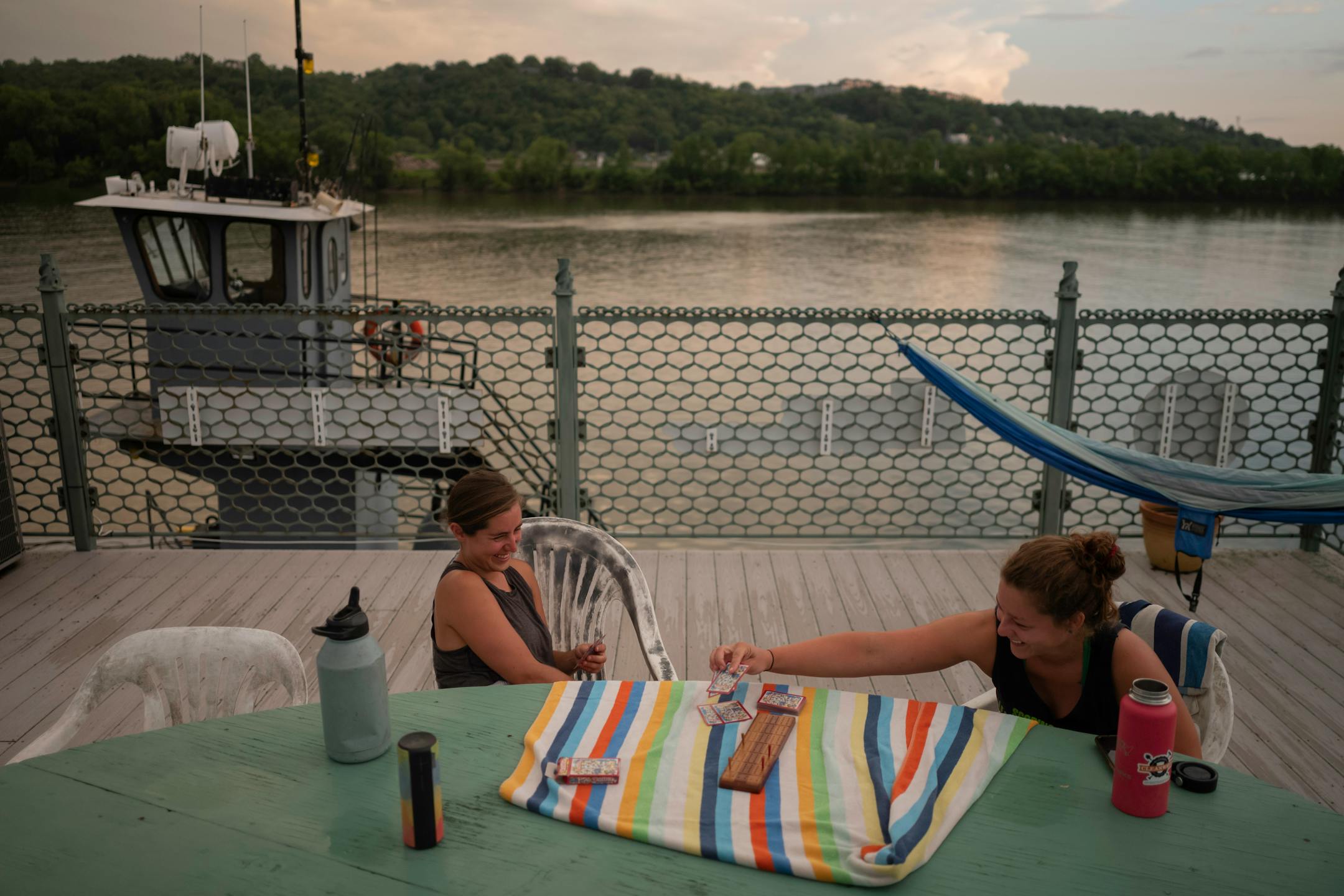 After dinner, Rachel Loomis, left, and Callie Schafer laugh while playing a game of cribbage on Tuesday, July 13, 2021 in Cincinnati, Ohio.