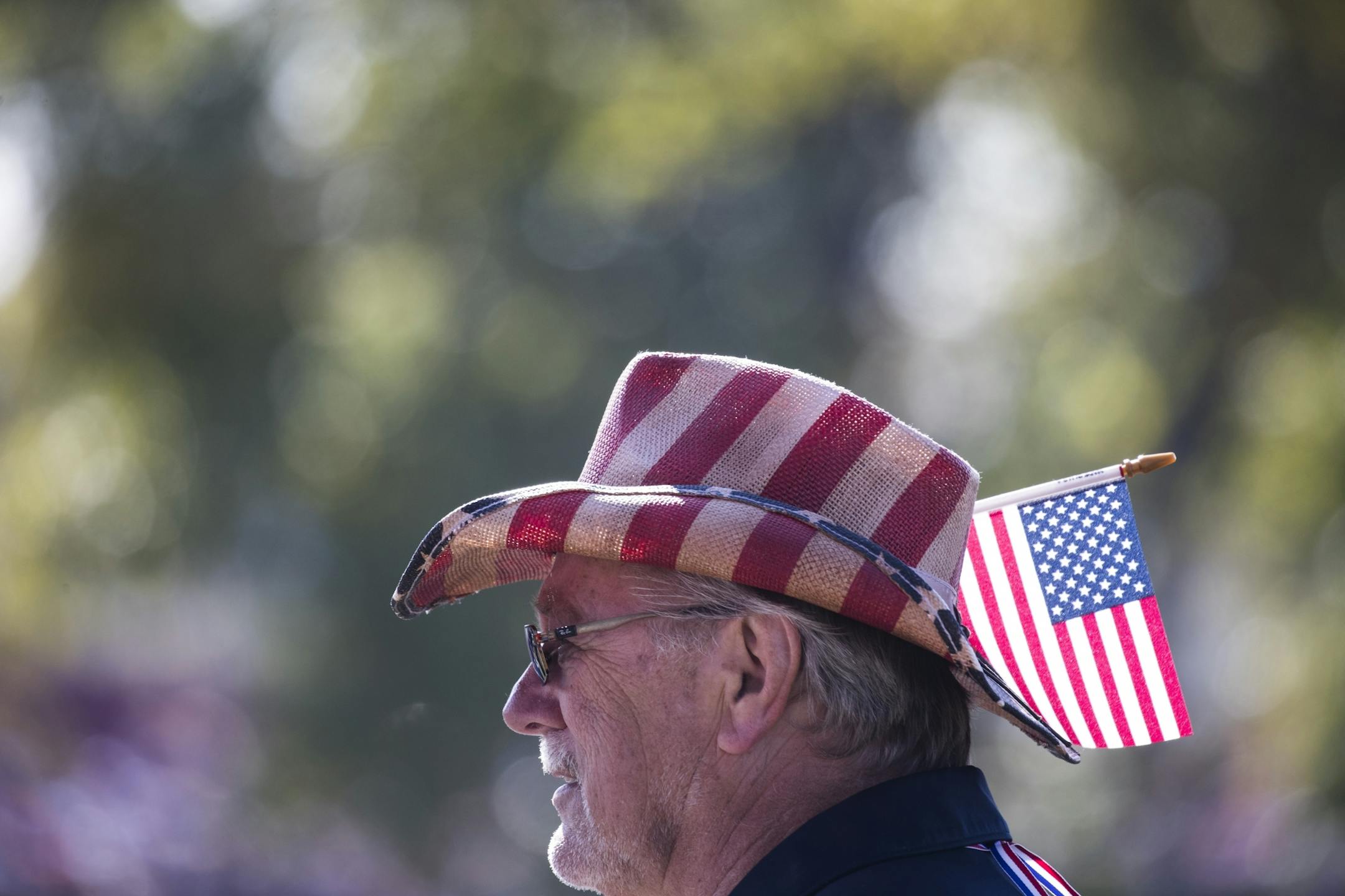 A fan wears a patriotic hat and flag.