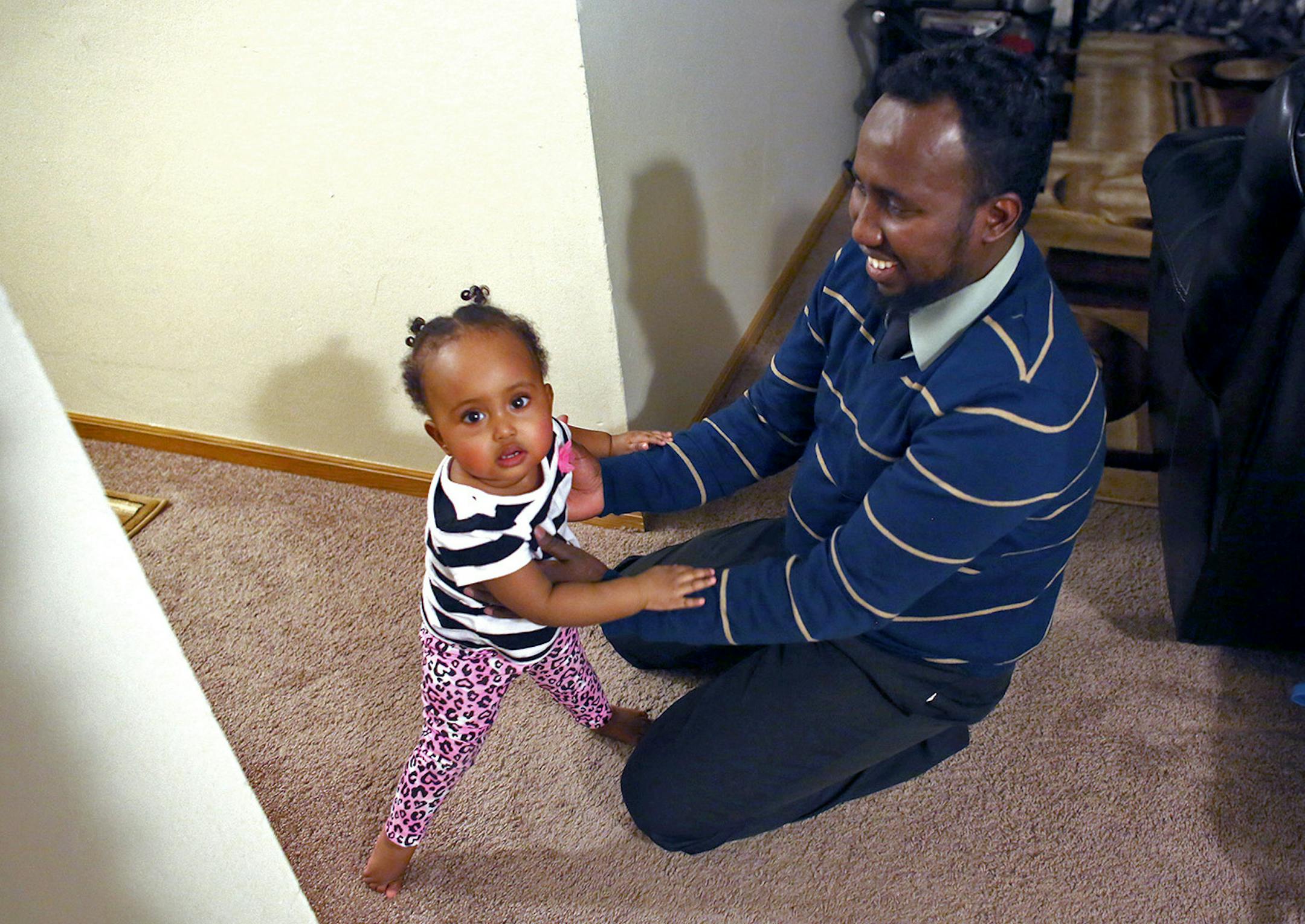 Abdi Nour Barkhad, of St Paul, played with his nearly one year-old daughter Shadiya Abdi. ] (KYNDELL HARKNESS/STAR TRIBUNE) kyndell.harkness@startribune.com In Abdi Nour Barkhad's home in St Paul, Min., Friday, February 6, 2015. ORG XMIT: MIN1502062017063095