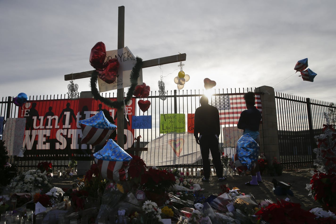 People pay respects at a makeshift memorial honoring the victims of Wednesday's shooting rampage that killed 14 people, Saturday, Dec. 5, 2015, in San Bernardino, Calif.