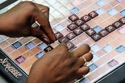 Linda Williams of Laurel, Maryland, places her letters during a 2001 Scrabble tournament sponsored by the National Scrabble Association Club 171. Illu