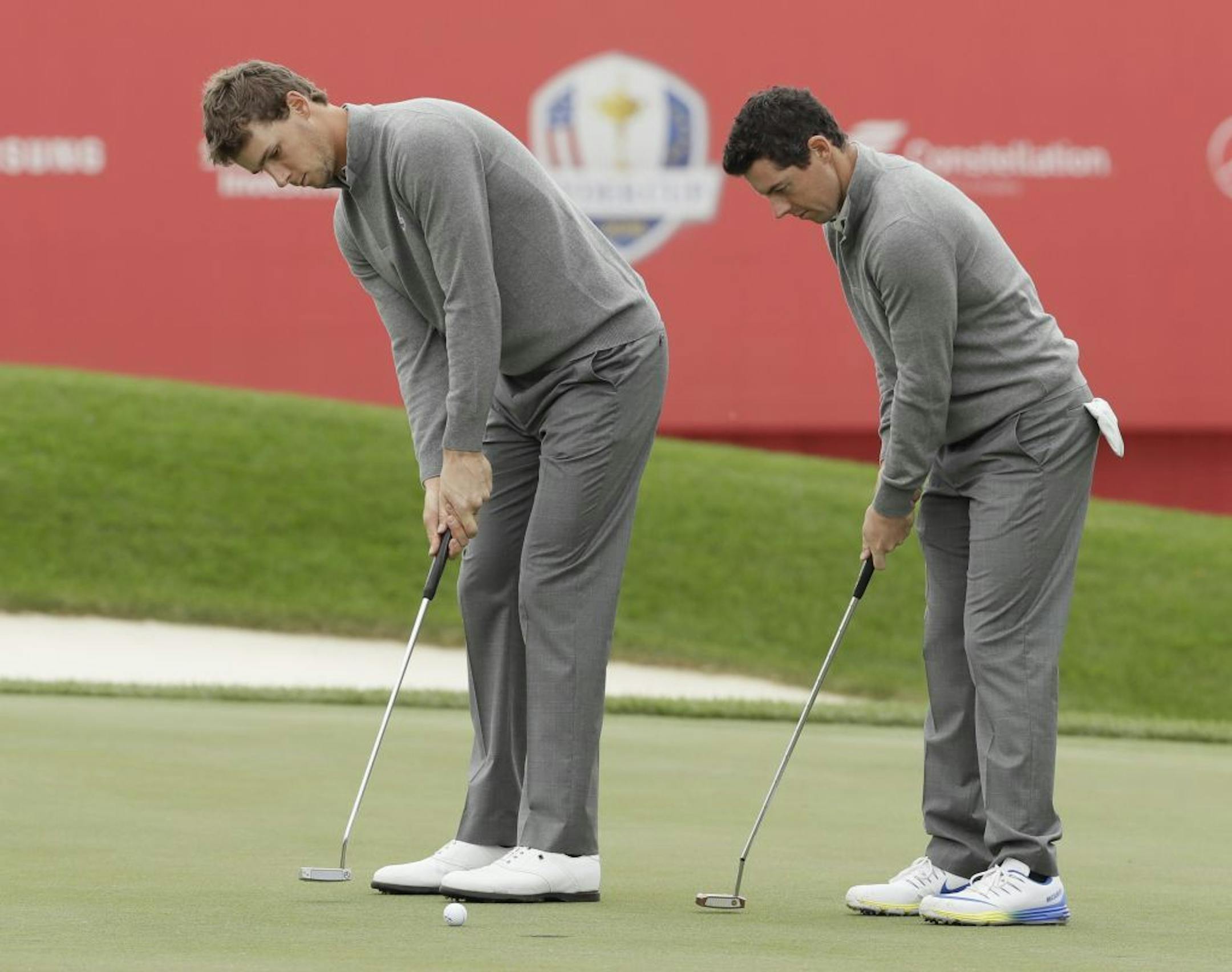 Europe's Rory McIlroy and Thomas Pieters putt on the 18th hole during a practice round for the Ryder Cup golf tournament Wednesday at Hazeltine National Golf Club.