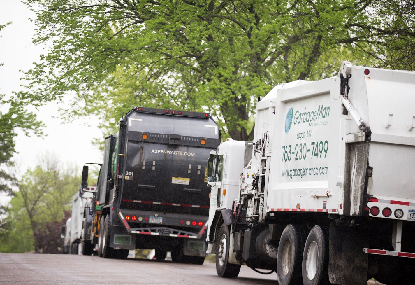 Waste disposal trucks line up on trash pickup day in Bloomington between France Avenue and Normandale Boulevard on Thursday, May 7, 2015.