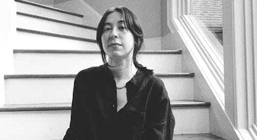 photo of author Alexandra Tanner, seated on a spiral staircase