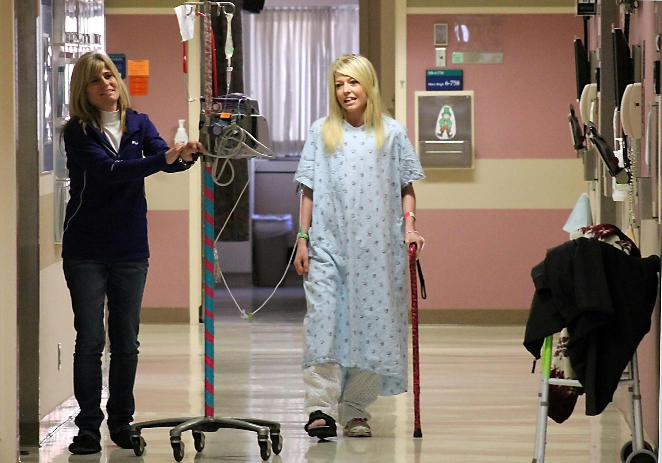 Alyssa Sandeen, 23, and her mother walked down the hallway outside Alyssa’s hospital room at St. Marys Hospital in Rochester, where she is staying in order to be ready on short notice to receive a second heart transplant as soon as a suitable organ becomes available.