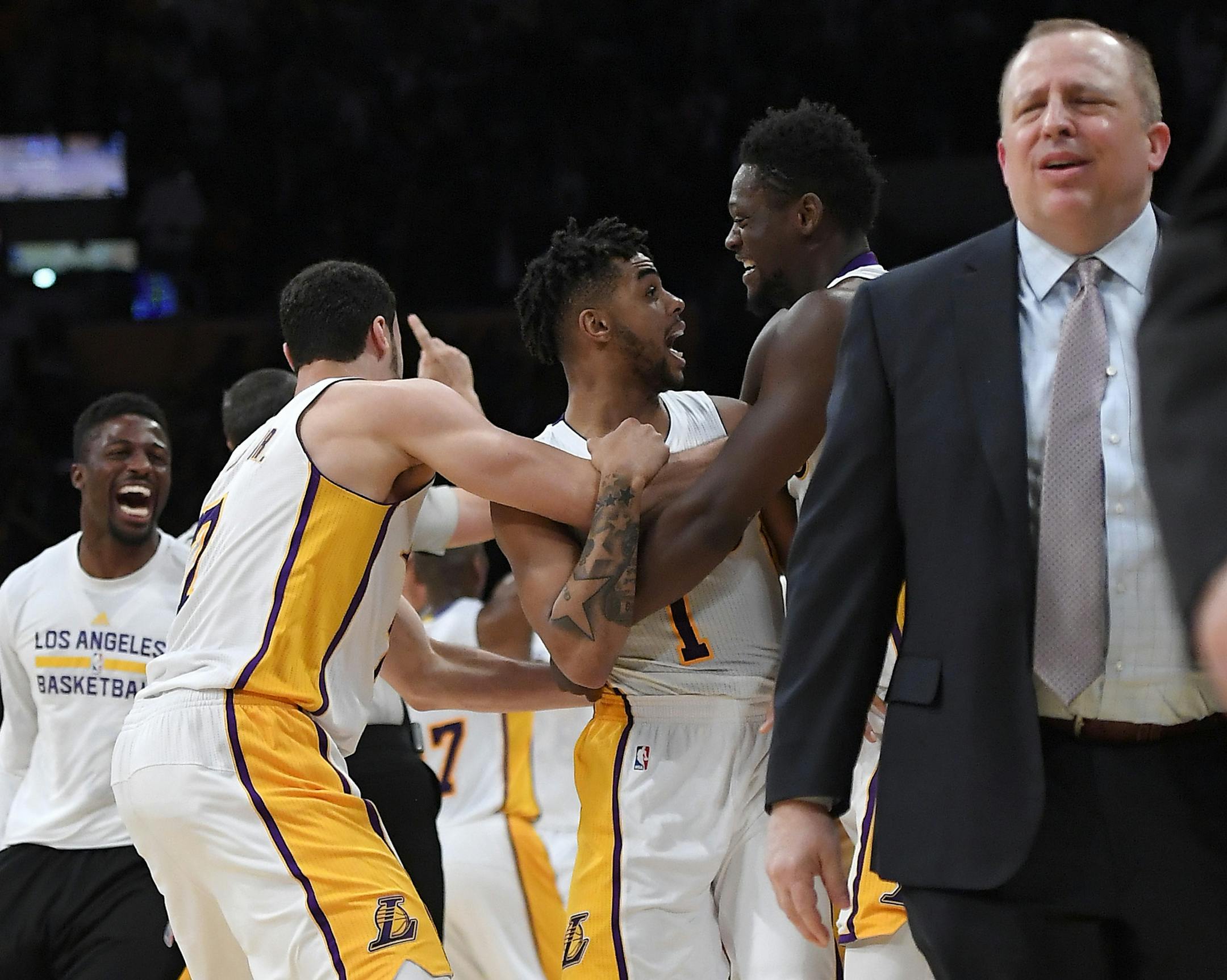 Los Angeles Lakers guard D'Angelo Russell (1) celebrates with teammates after hitting a game-winning three point shot as Minnesota Timberwolves head coach Tom Thibodeau walks off the court during the second half of an NBA basketball game, Sunday, April 9, 2017, in Los Angeles. The Lakers won 110-109. (AP Photo/Mark J. Terrill)